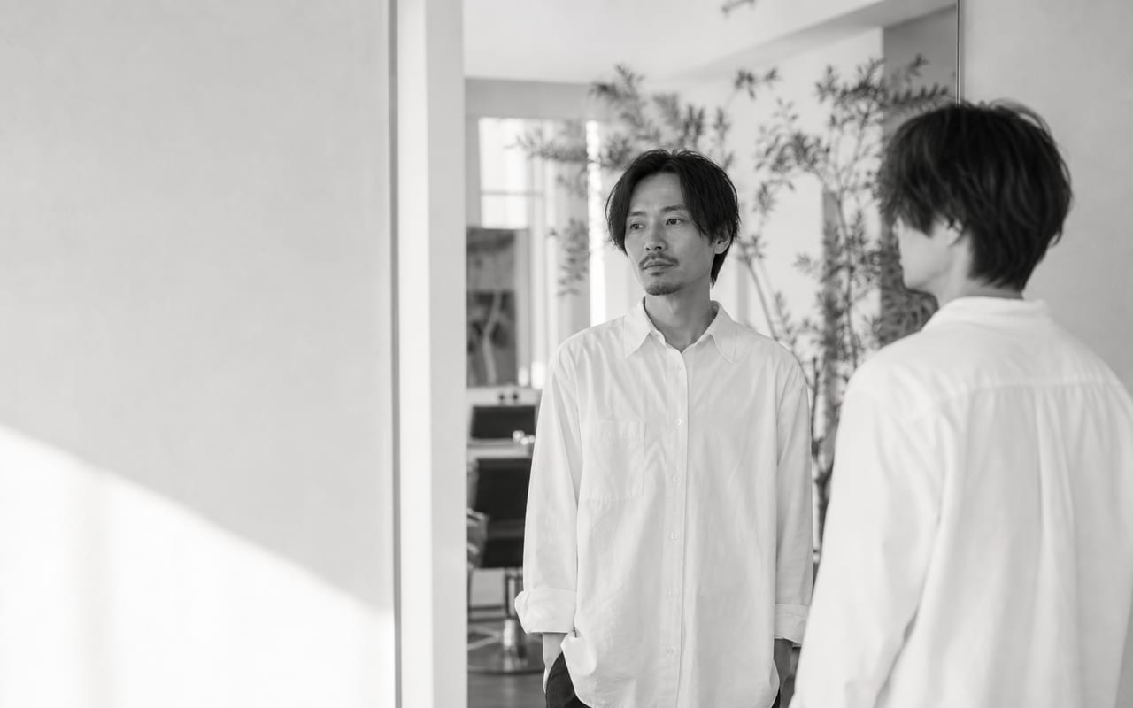 アトリエの鏡の前に立つ、代表スタイリスト早乙女朔