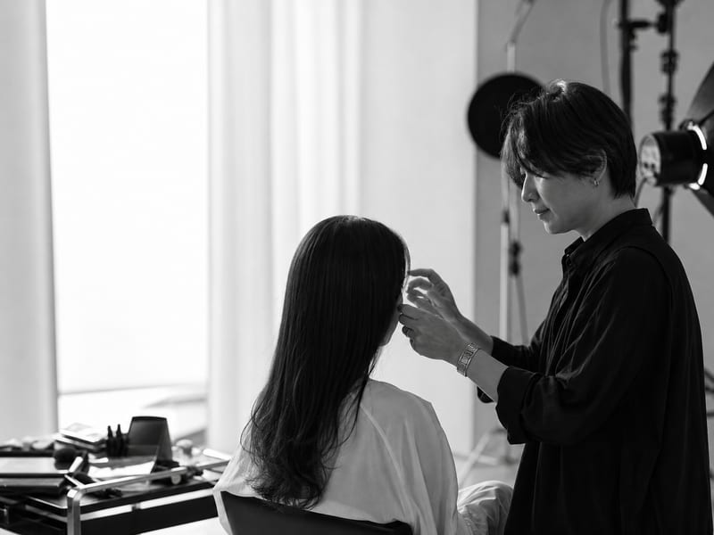 撮影スタジオでヘアメイクを整える手元